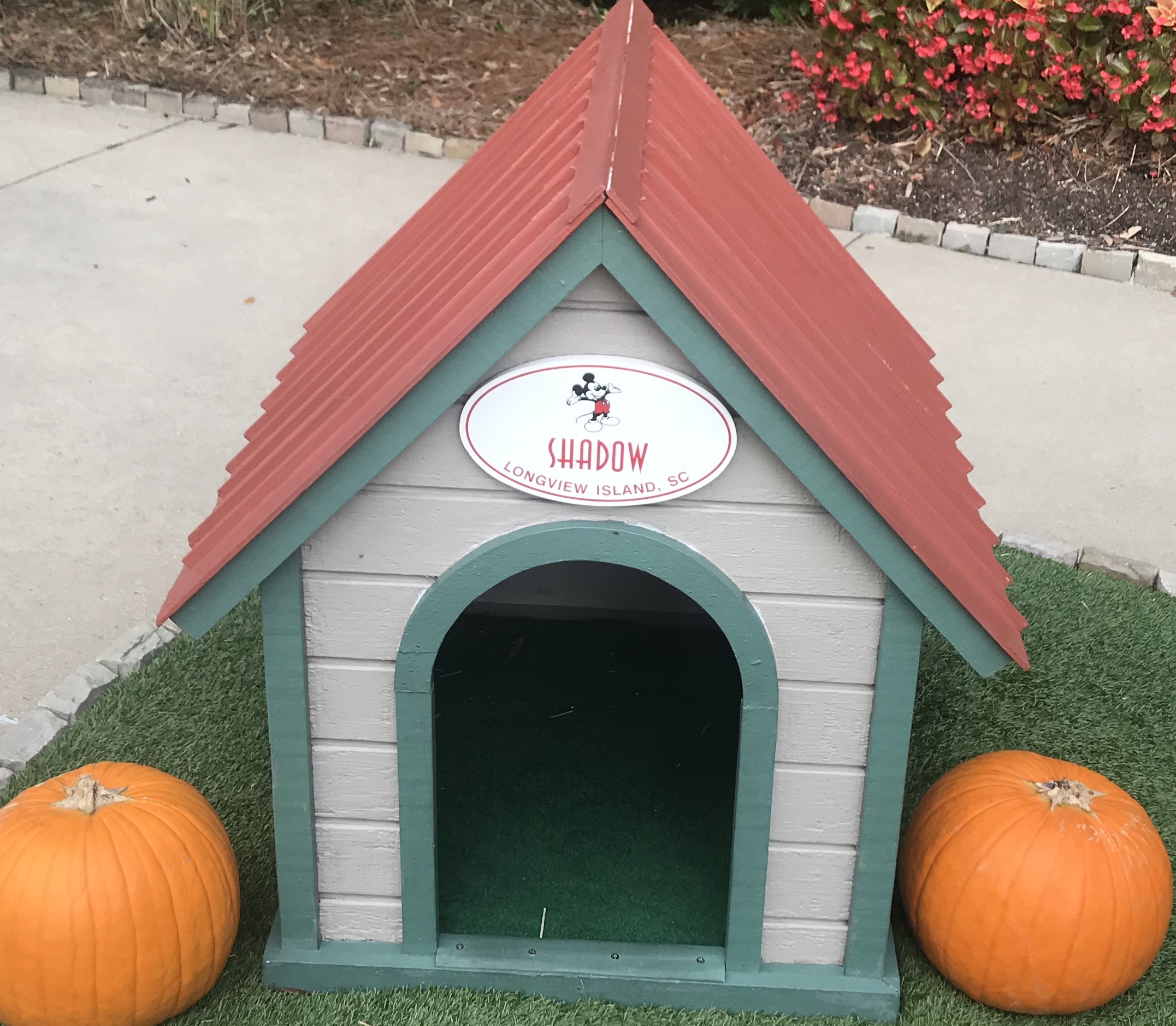 Vero Beach Resort | A Small House With Green Outline and Red Roof That Has Two Pumpkin In Each Side