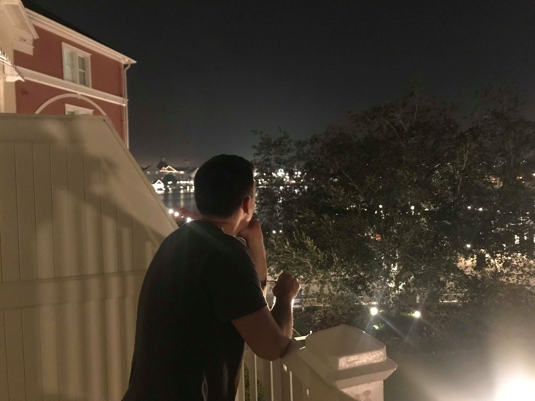 Boardwalk Villas Deluxe Studio | A Man Looking Outside The Balcony At Night
