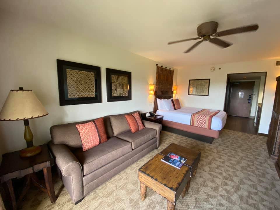 DVC Animal Kingdom Villas | Rooms with Couch and Bed with Dark Woods and Warm Color Theme