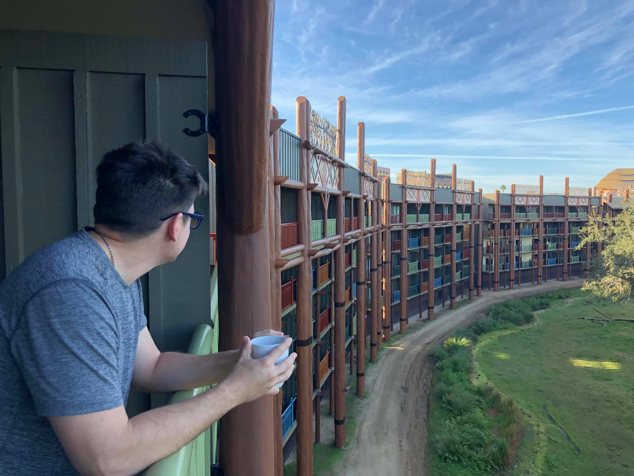 Animal Kingdom Villas | A Man Holding a Cup Of Coffee At the Balcony