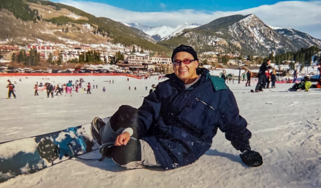 JP, Jason Padilla posing in front of beautiful mountains sitting in the snow.