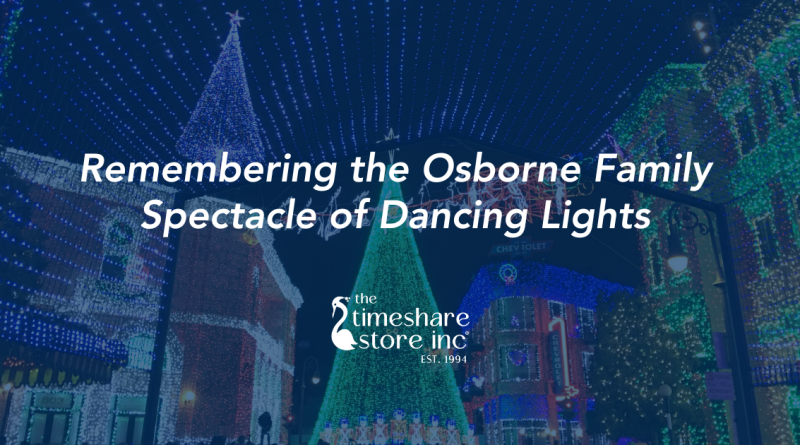The Osborne Family Spectacle of Dancing Lights at Disney’s Hollywood Studios, featuring colorful buildings, hanging Christmas trees, and a canopy of blue and white lights across the street.