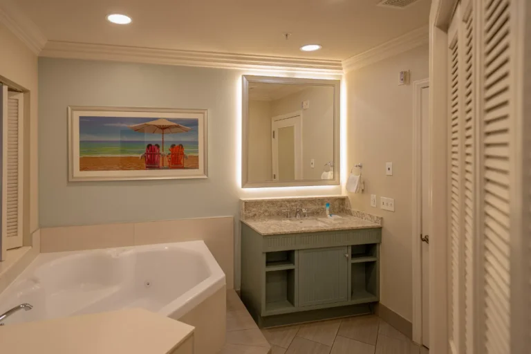 Bathroom with a sink, mirror, bathtub, and painting in the Old Key West one-bedroom villa